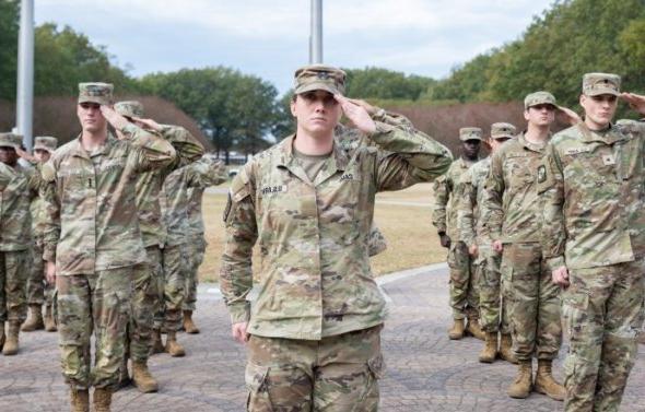 A group of people in military uniform saluting.